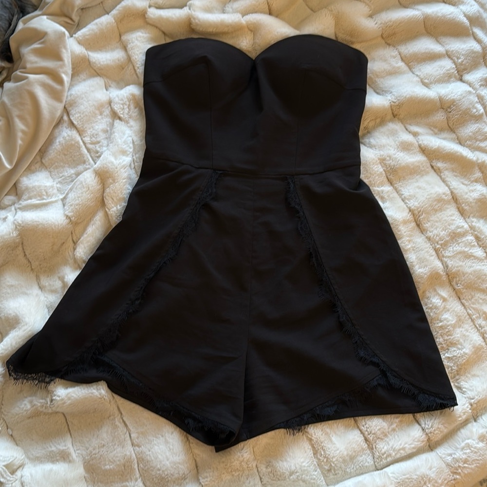 Bebe black romper strapless with padded bust and lace detail.